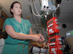 Dr. Anna Dvorak, a pulmonary critical care physician with Seton Medical Center, Austin, Texas, uses a clamp to demonstrate pressure during a class on ECMO, a heart-lung bypass system that provides temporary heart and lung function to critically ill patients during periods of severe cardiopulmonary failure. (U.S. Air Force photo by Staff Sgt. Robert Barnett/Released)